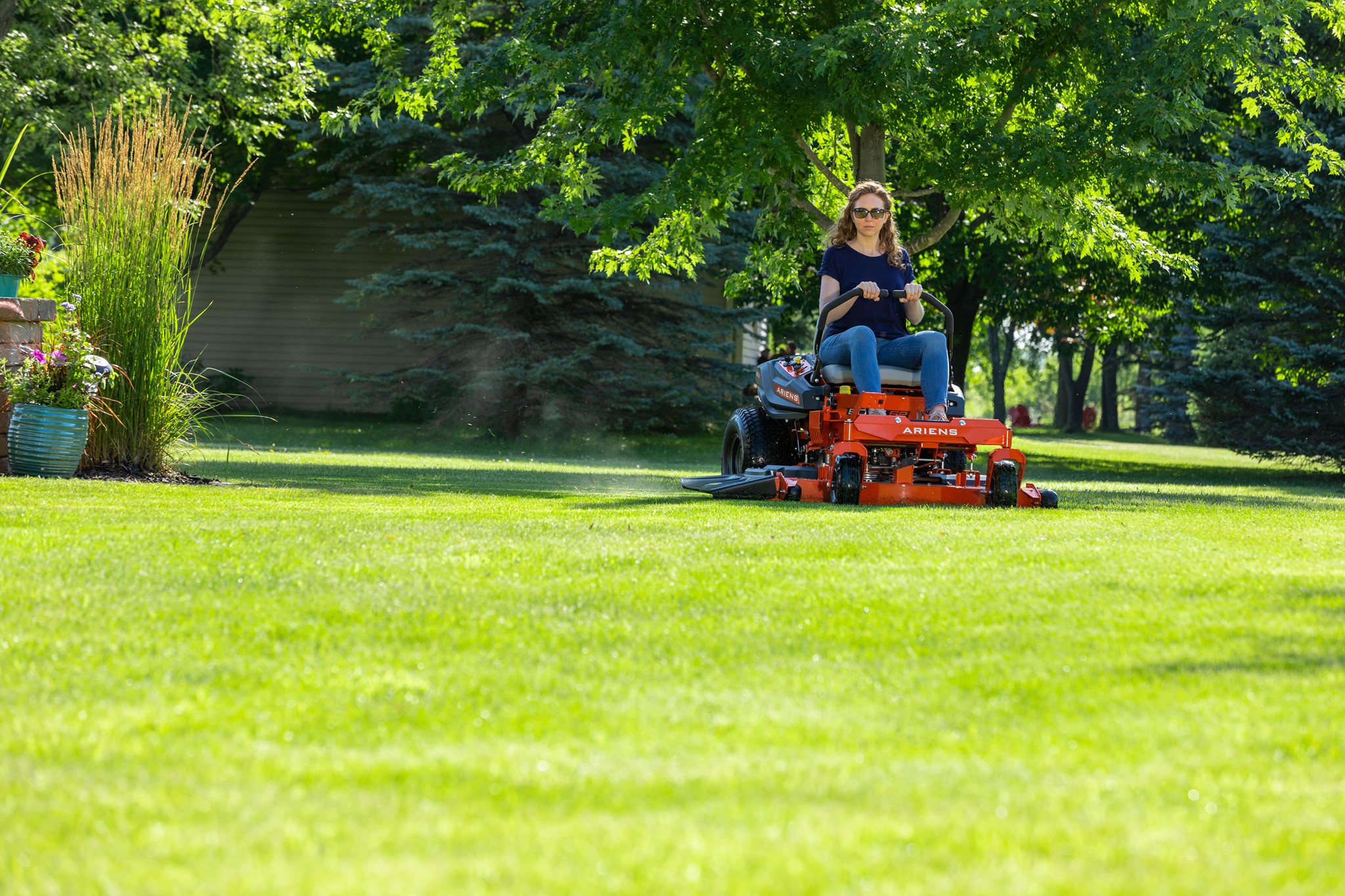 a woman sitting on a lawnmower