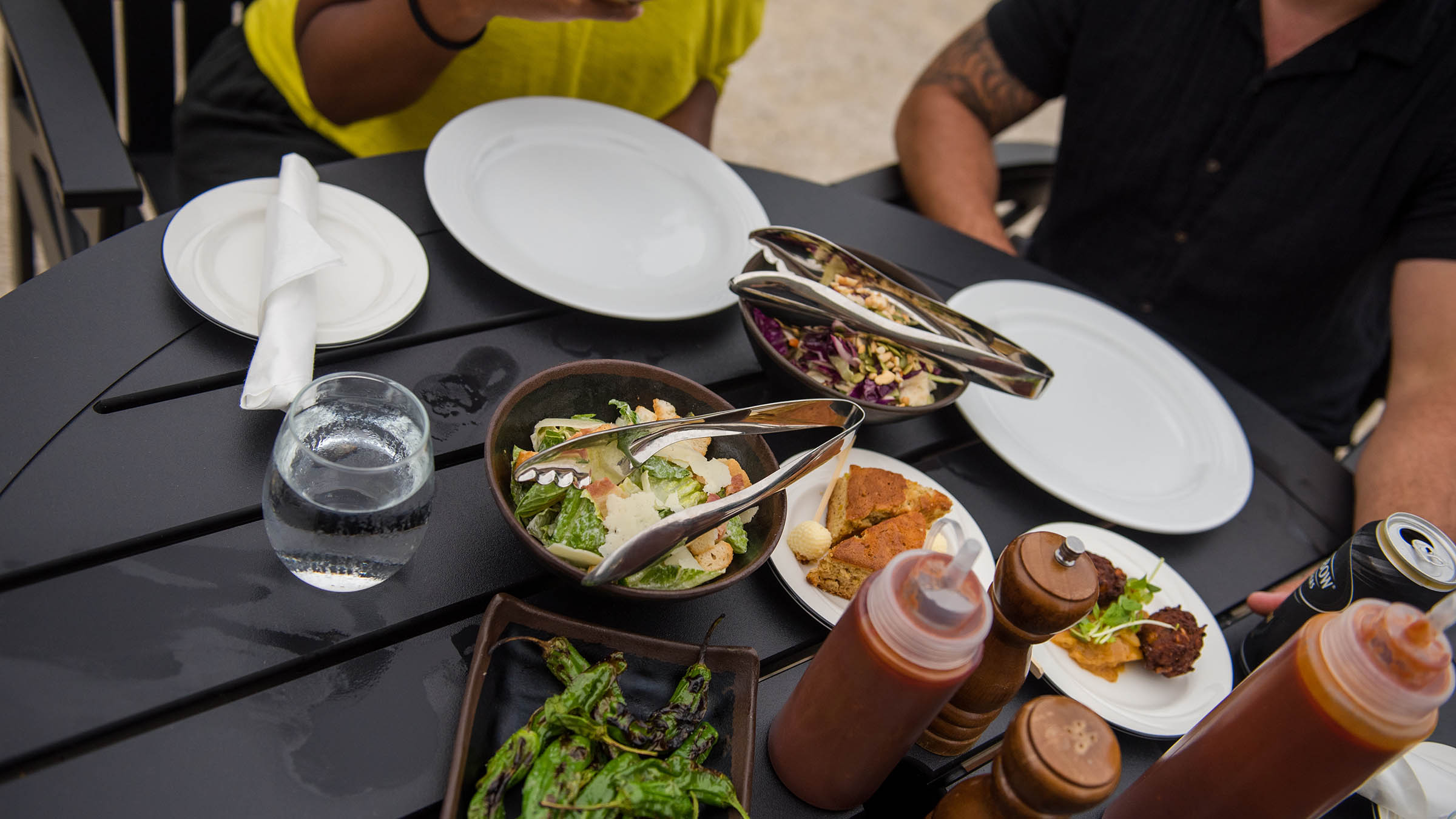 a table with plates of food and a bowl of salad