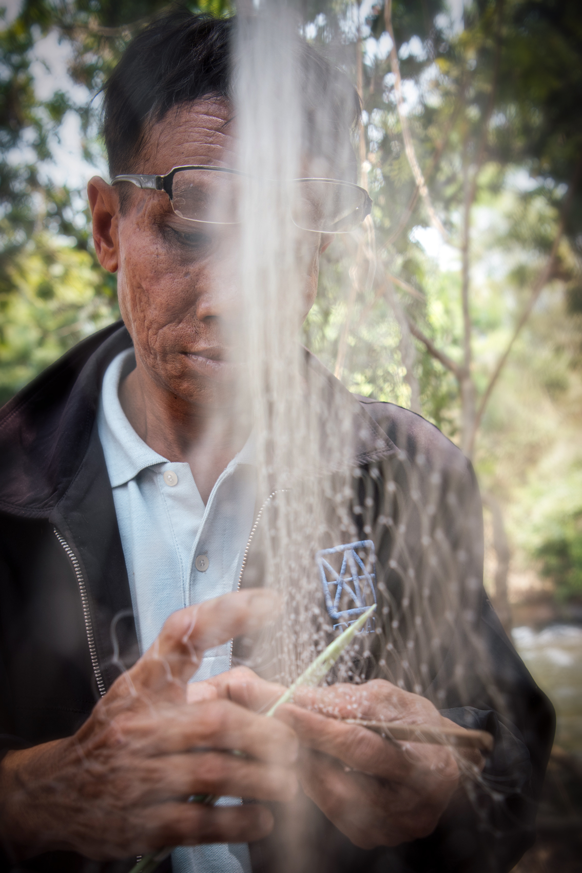 a man holding a stick with water coming out of his face