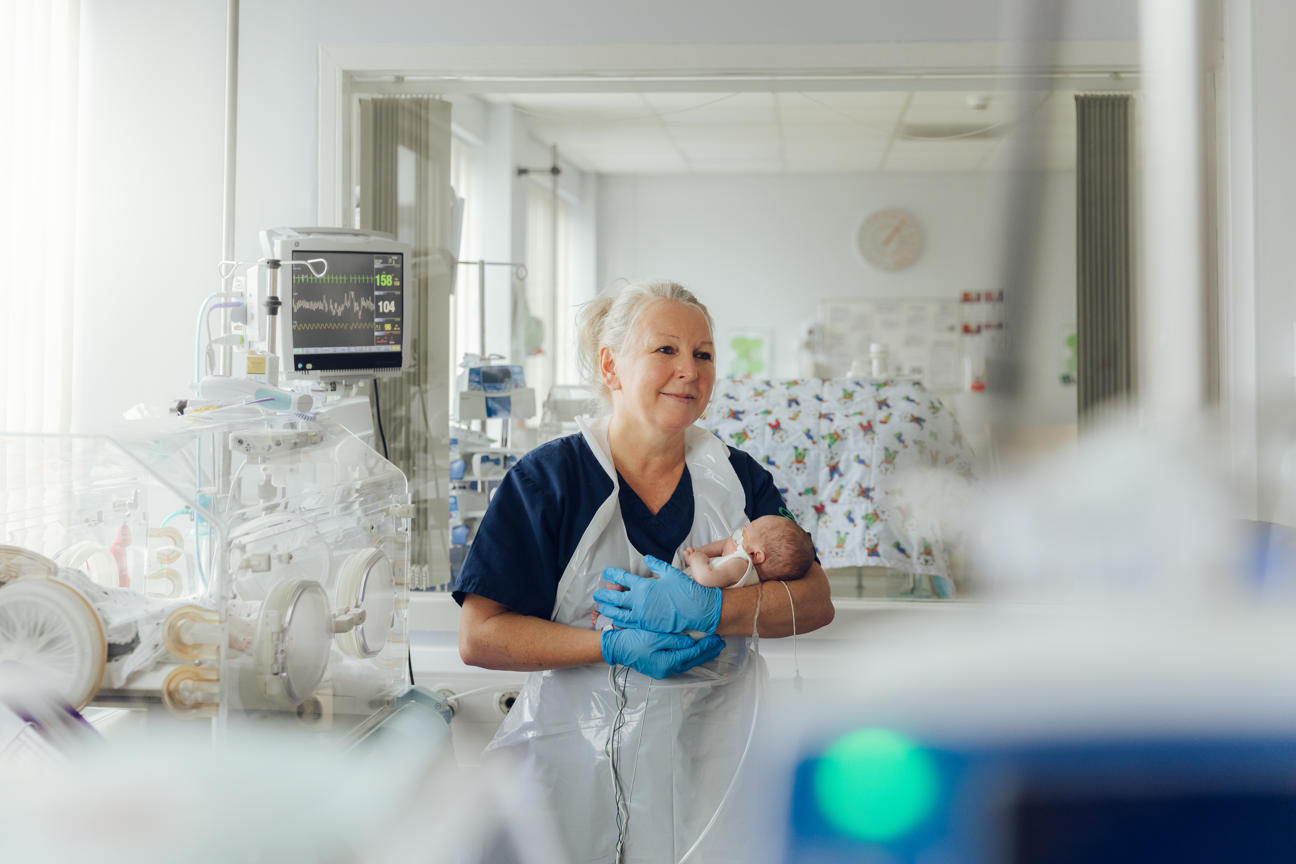 a woman holding a baby in a hospital room