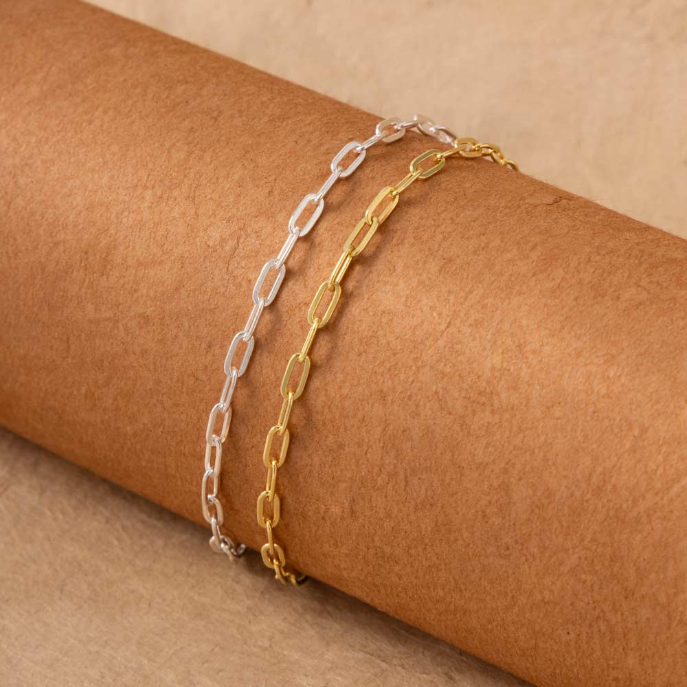 a pair of gold and silver chain bracelets