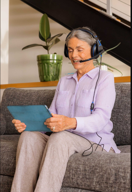 a woman wearing headphones and holding a tablet