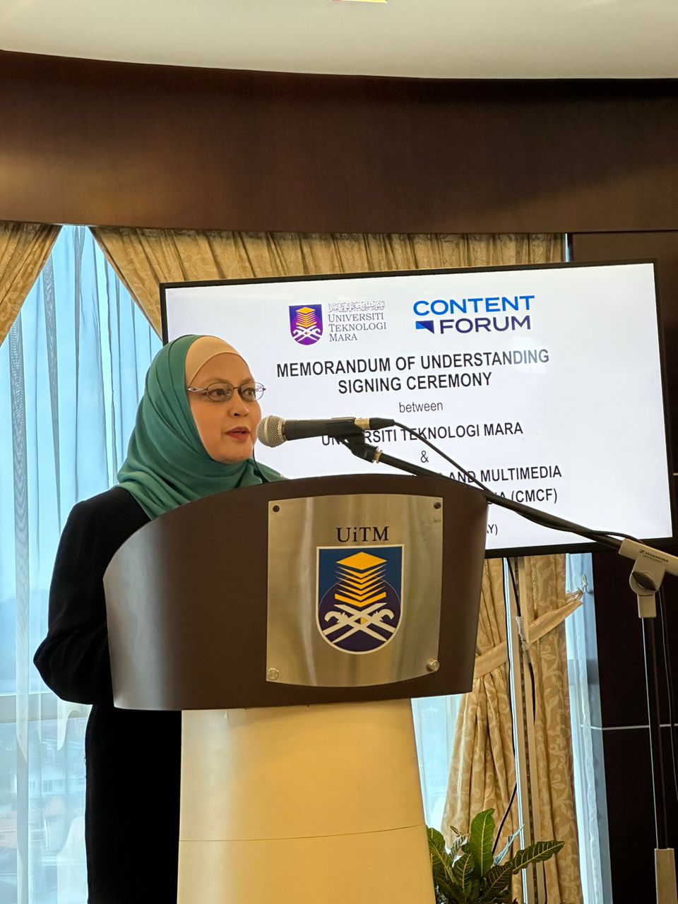 a woman standing at a podium speaking into a microphone