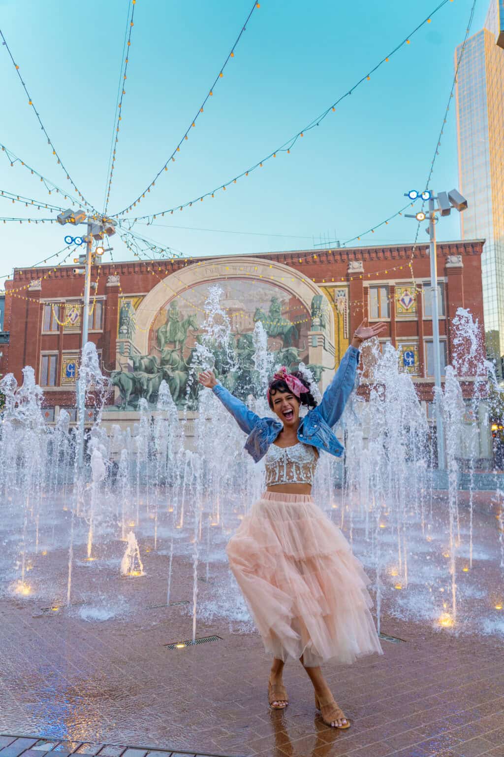 a woman in a tutu in front of a fountain