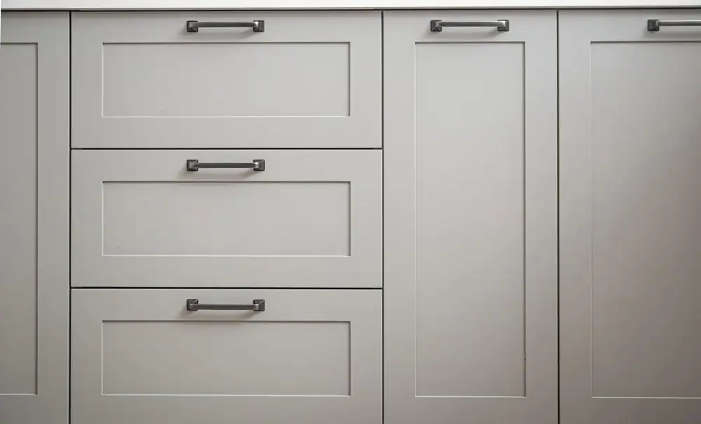 a white cabinet with black handles