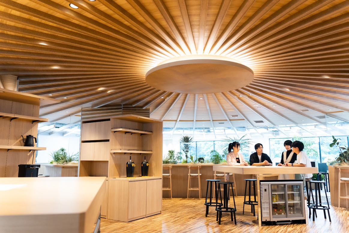 people sitting at a bar in a room with a ceiling and a light fixture