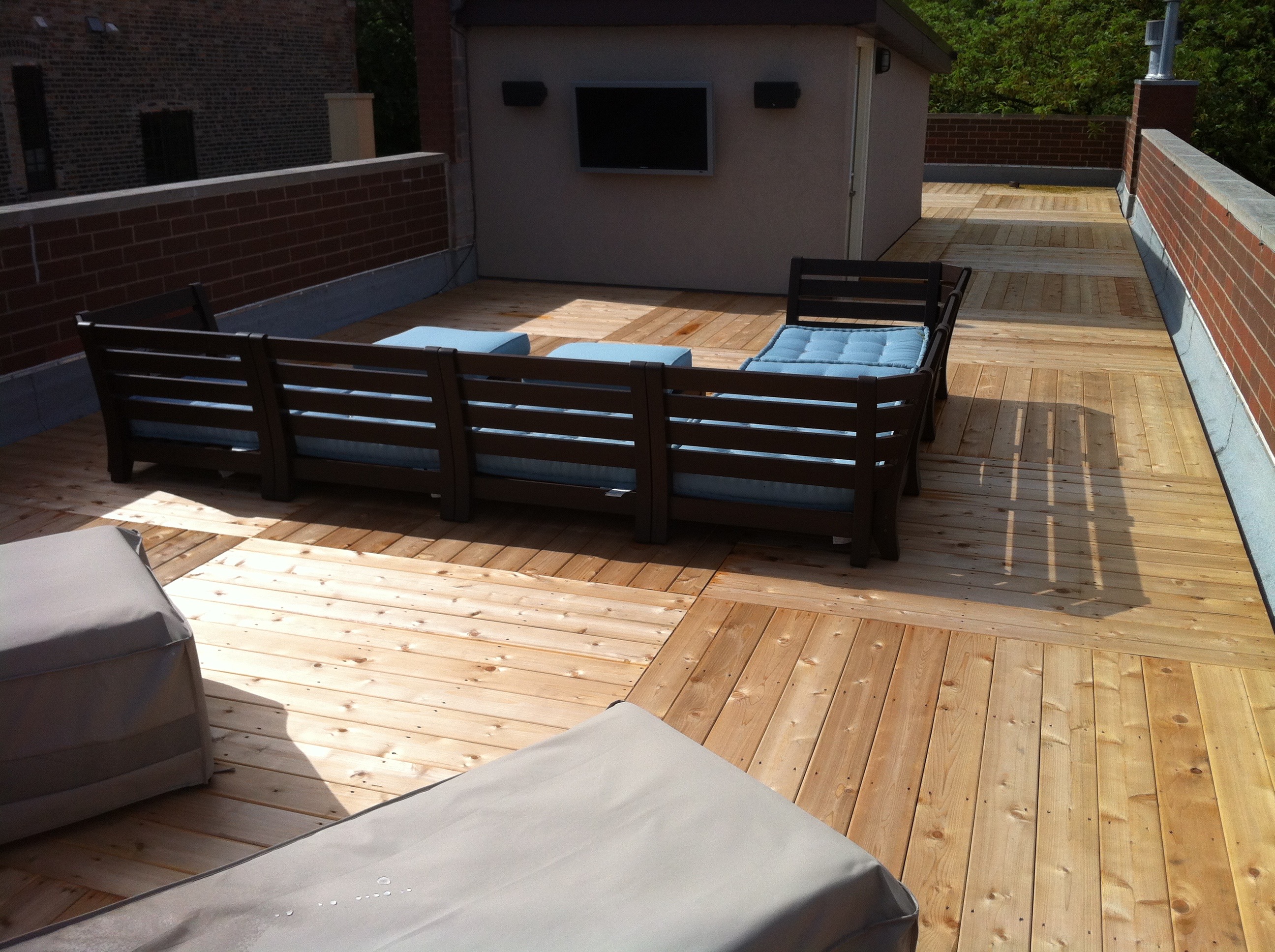 a deck with a couch and a small building