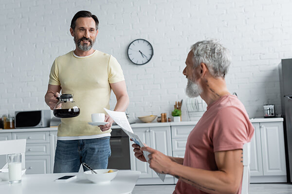 a man holding a coffee pot and a man holding a paper