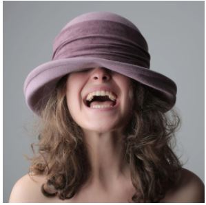 a woman wearing a hat and laughing