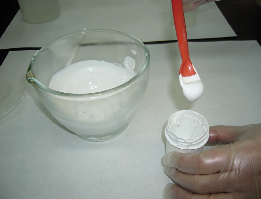 a person pouring white paint into a container