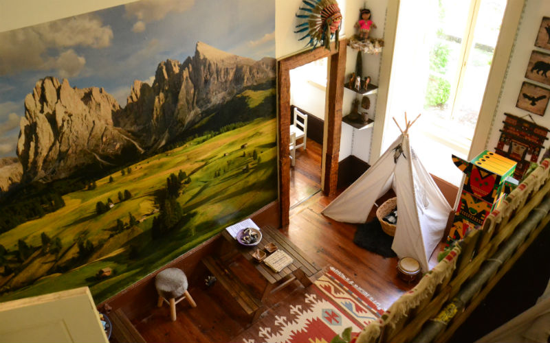 a room with a teepee and a painting on the wall