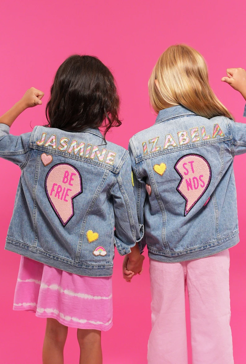 two girls wearing denim jackets with patches on them