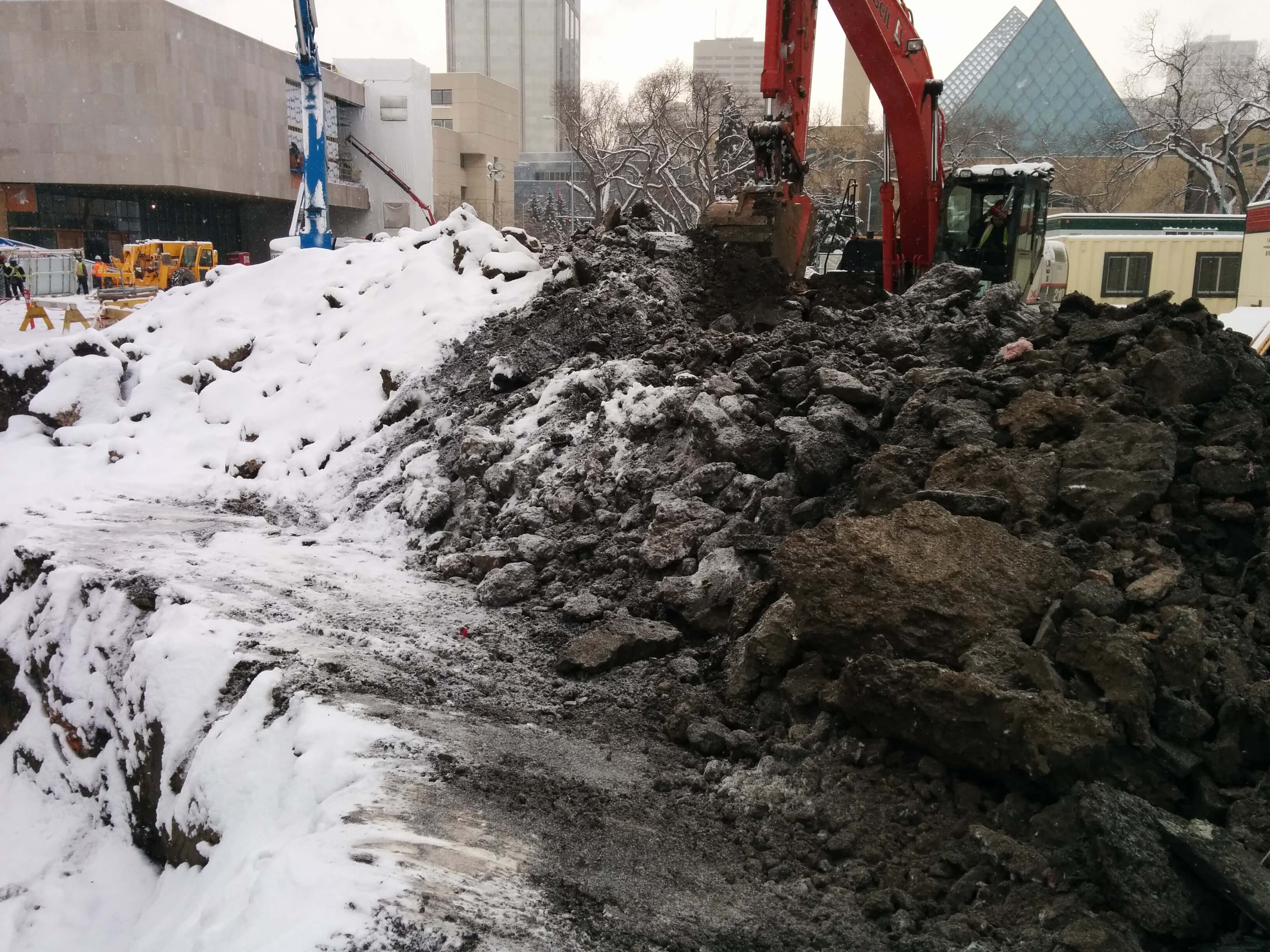 a construction site with a pile of dirt and snow