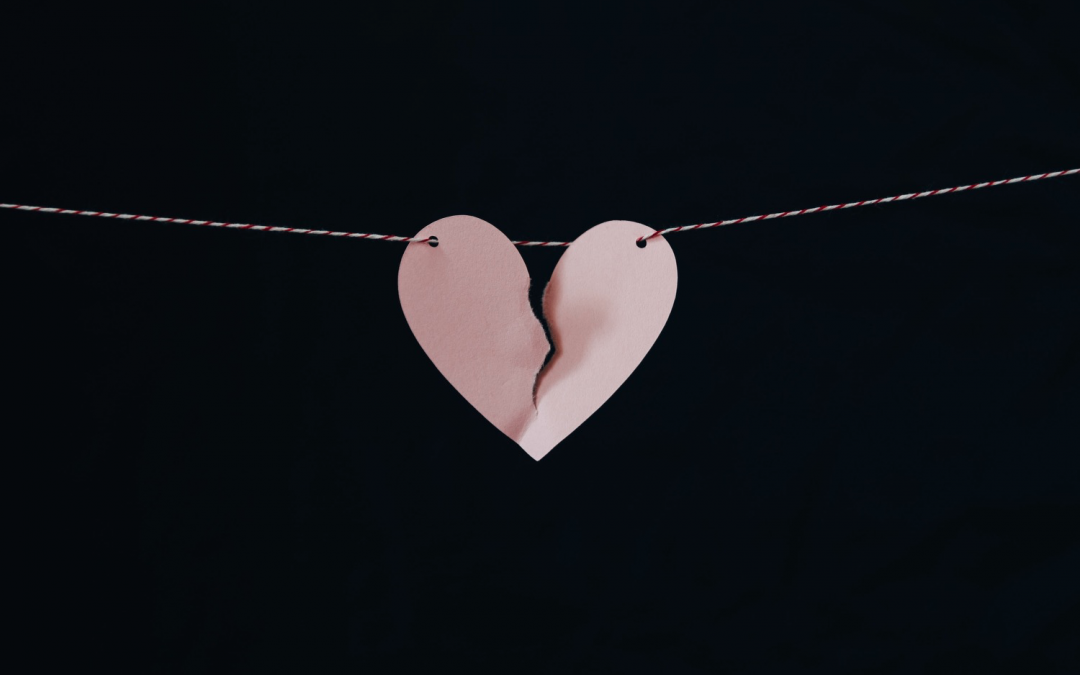 a paper heart with a broken piece of paper attached to a string