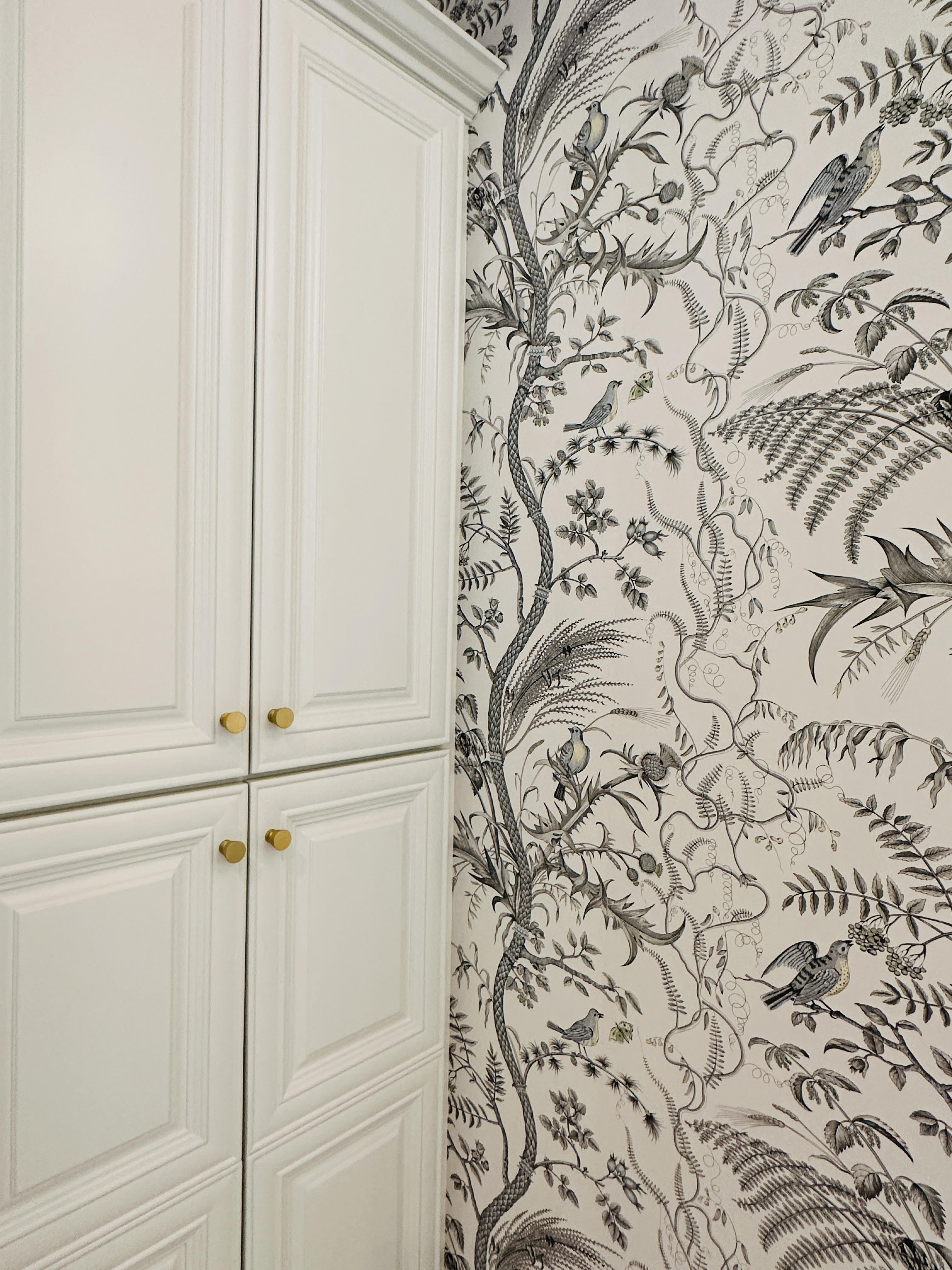 a white cabinet with a wallpaper