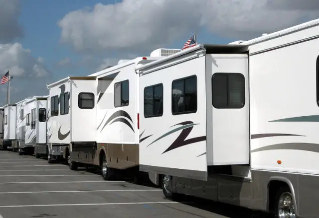 a row of recreational vehicles parked in a parking lot