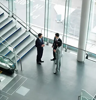 men standing in a room with stairs and windows