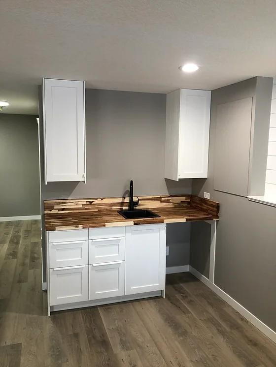 a kitchen with white cabinets and a wood countertop