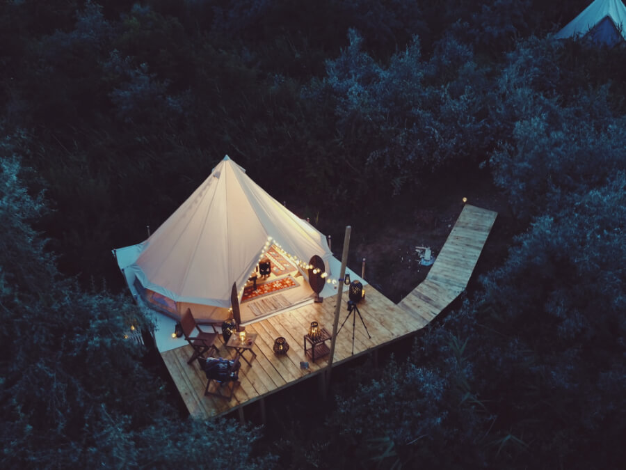 a tent on a deck surrounded by trees