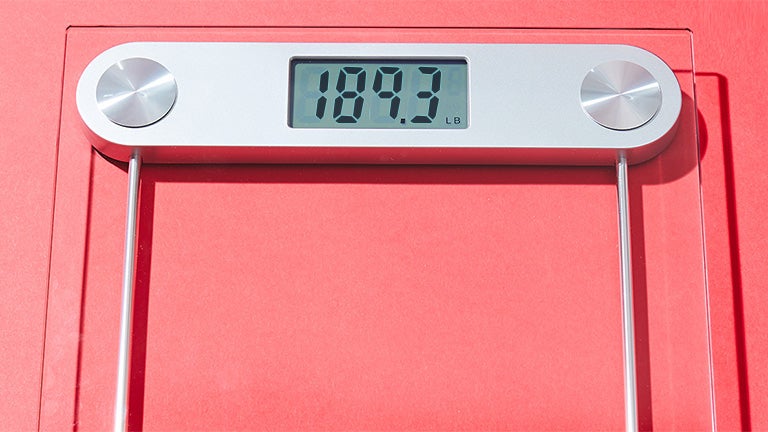 a digital scale on a red surface