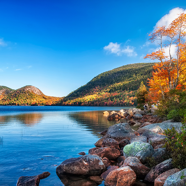 a lake with colorful trees and mountains