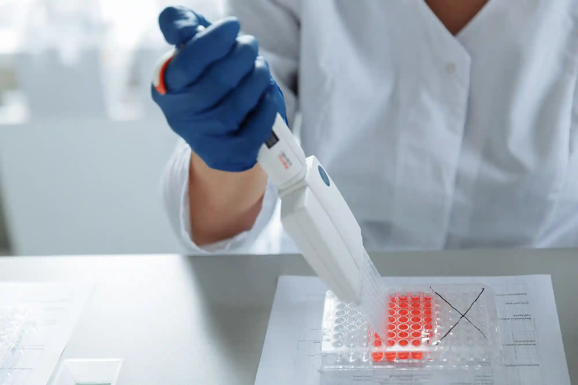 a person holding a pipette over a test tube