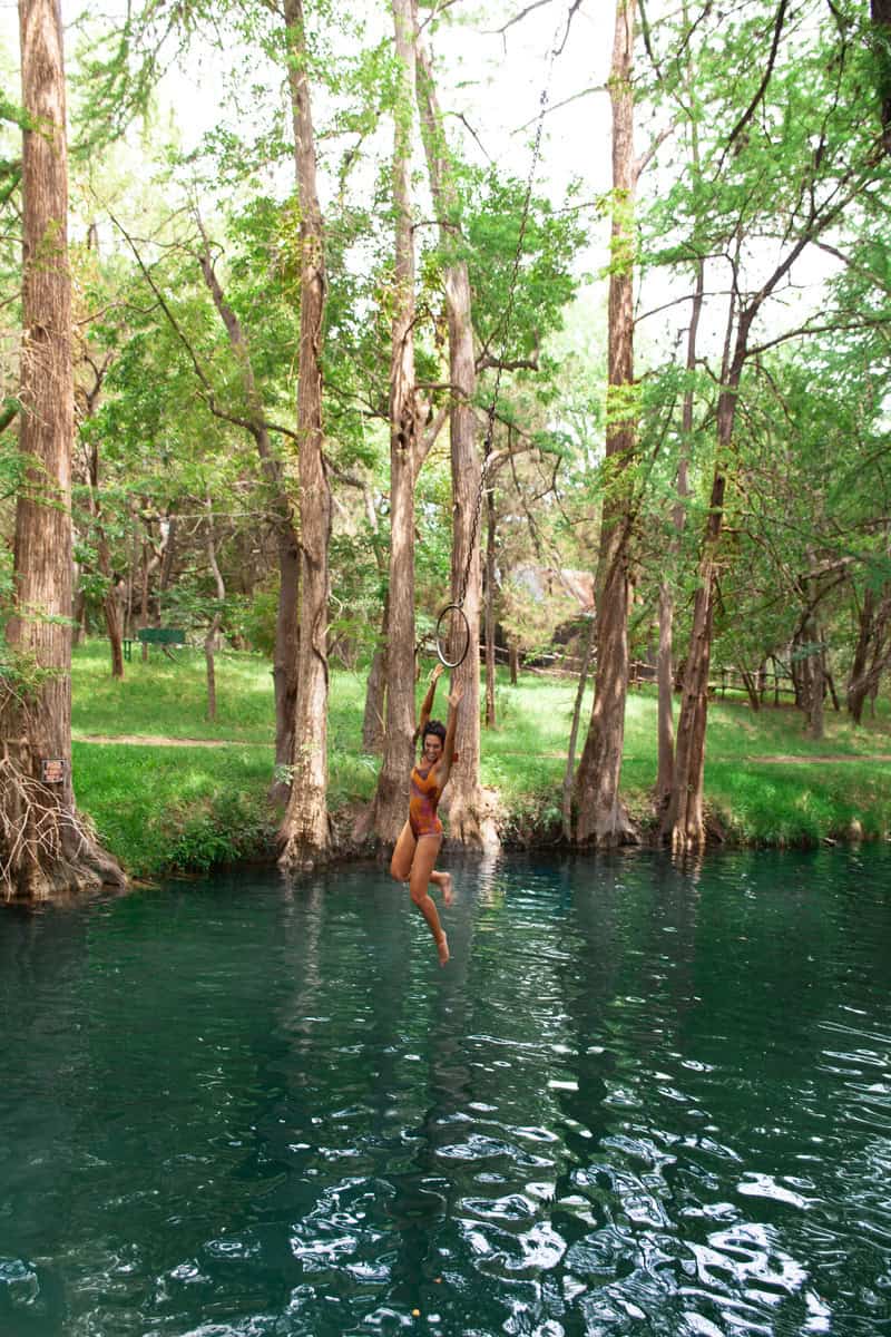 a woman in a swimsuit from a rope in a body of water
