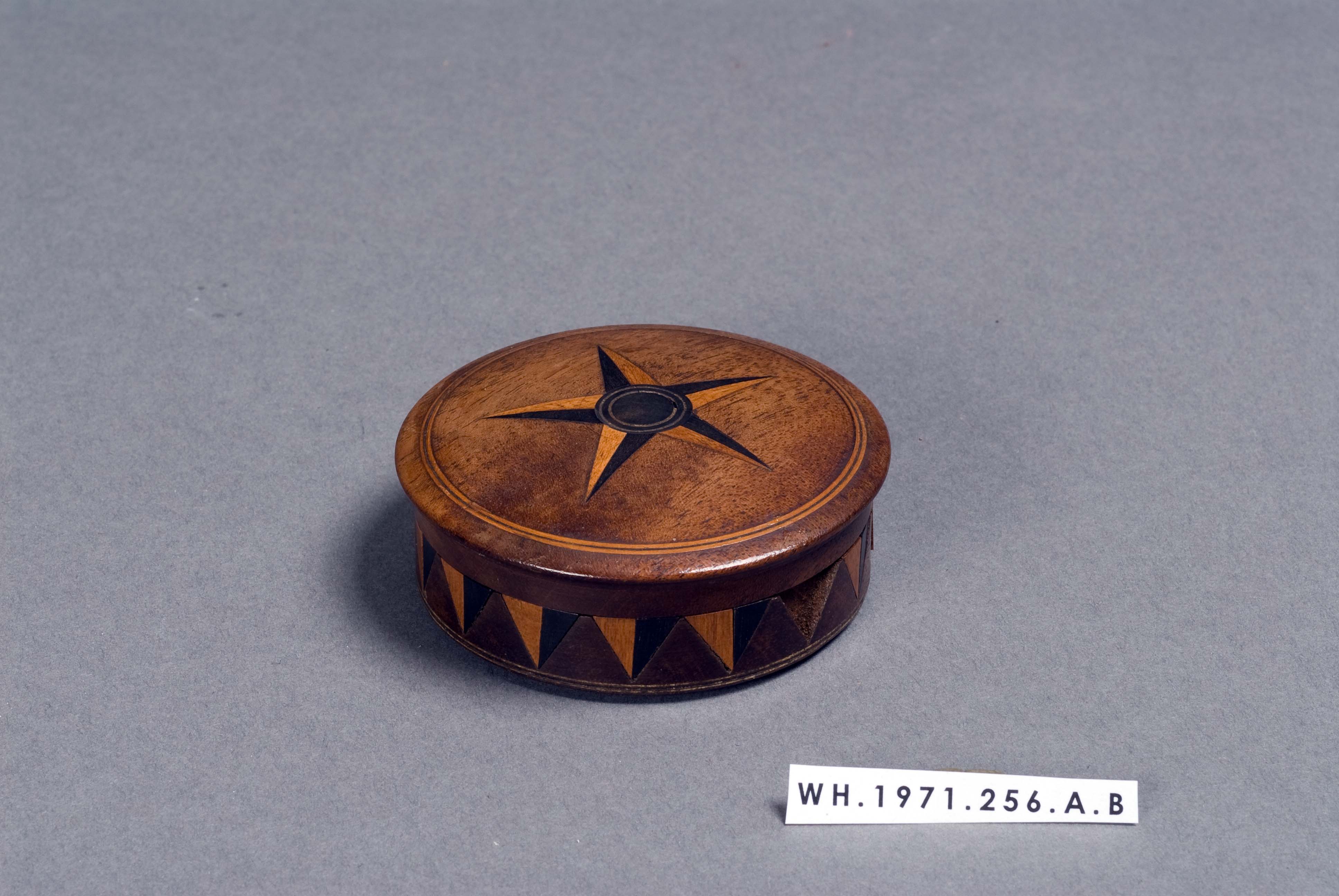 a round wooden box with a star design