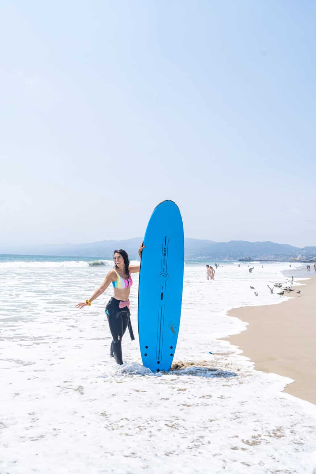 a woman holding a surfboard on a beach