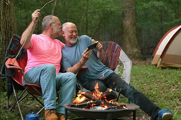 two men sitting around a fire