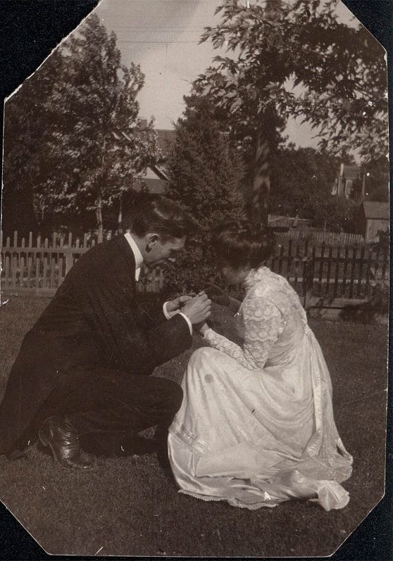 a man kneeling down to a woman's hand