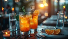 two glasses of orange liquid on a table