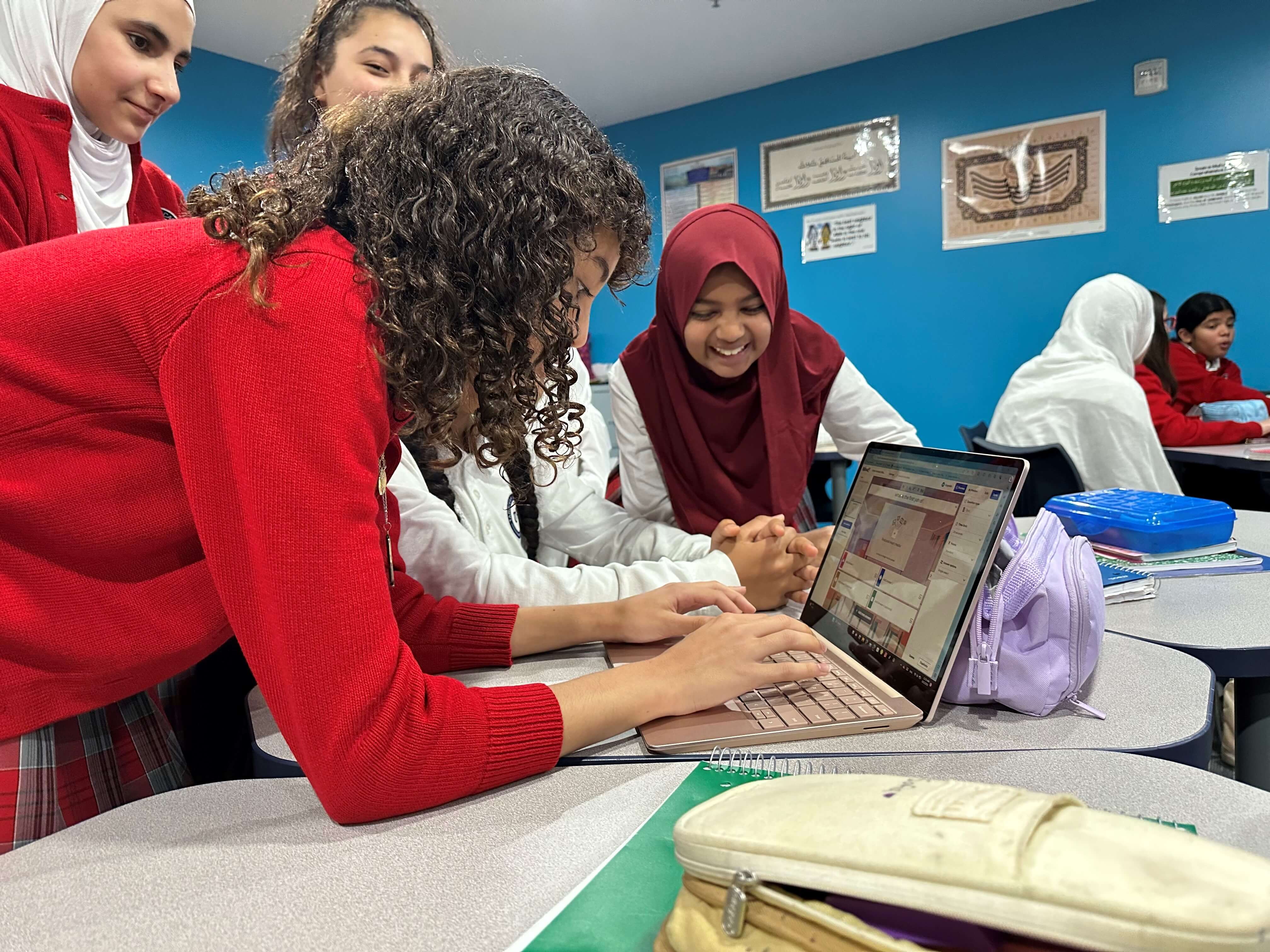 a group of girls looking at a laptop