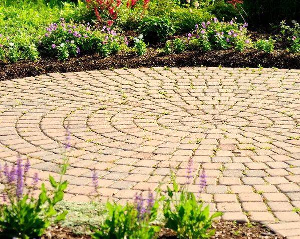 a circular brick walkway with flowers