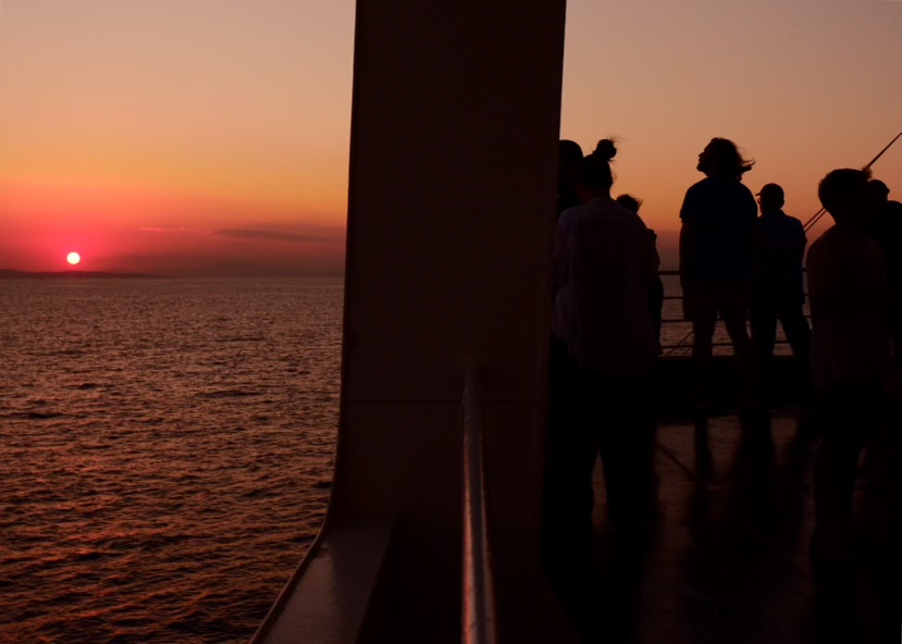 a group of people standing on a deck looking out to the ocean