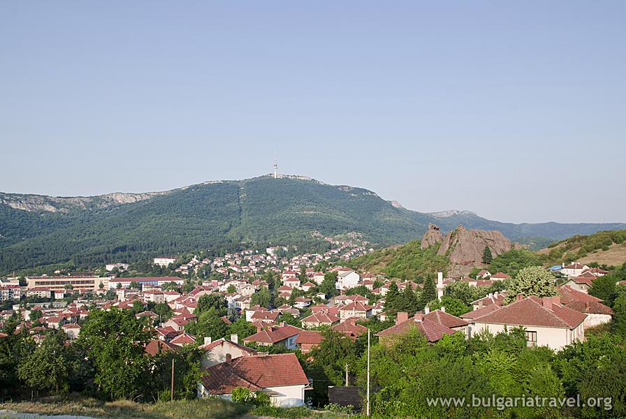 a city with red roofs and green hills