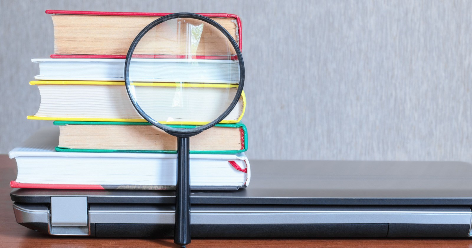 a magnifying glass on top of a stack of books