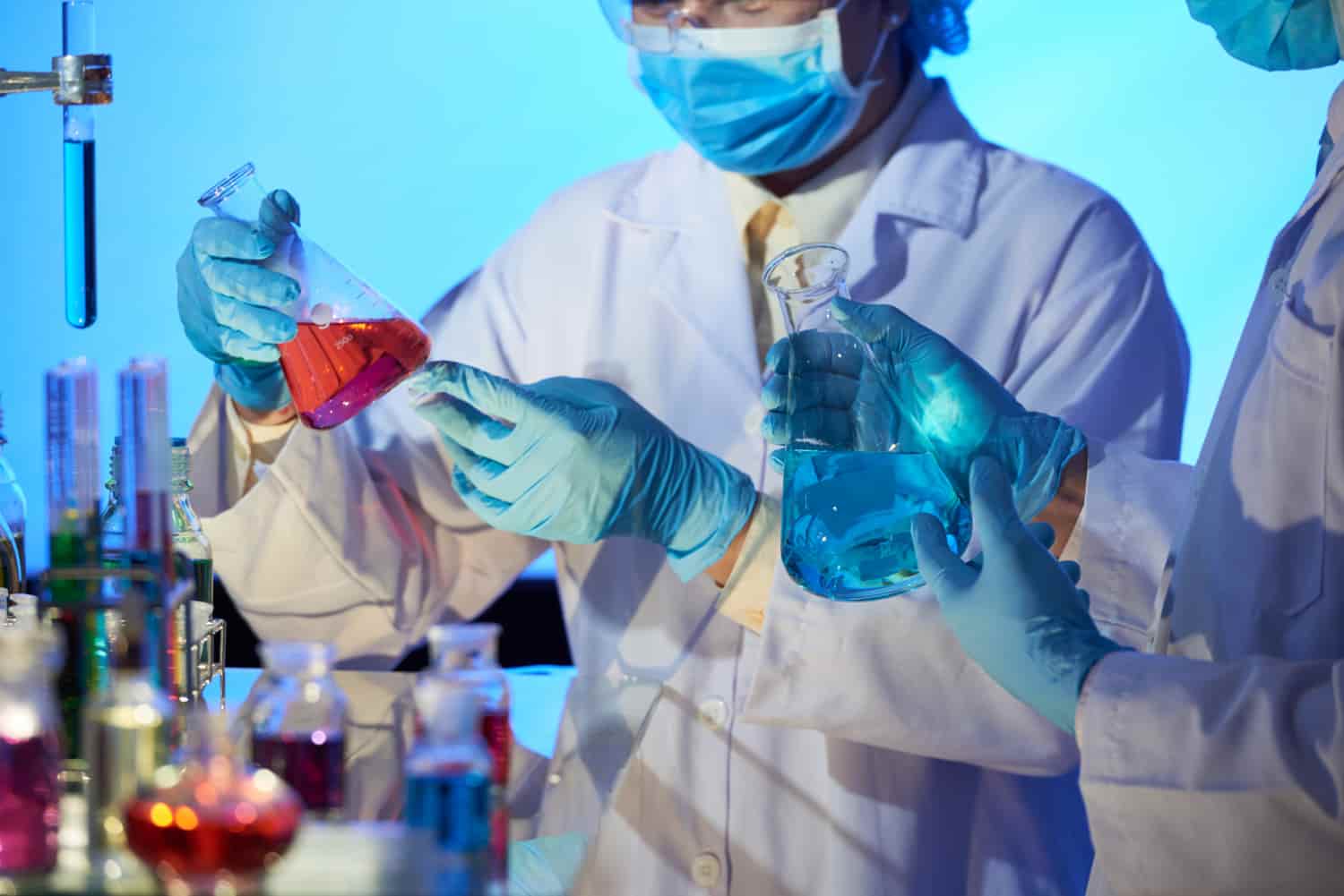 a group of people in lab coats holding beakers
