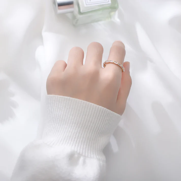 a hand with a ring on a white fabric