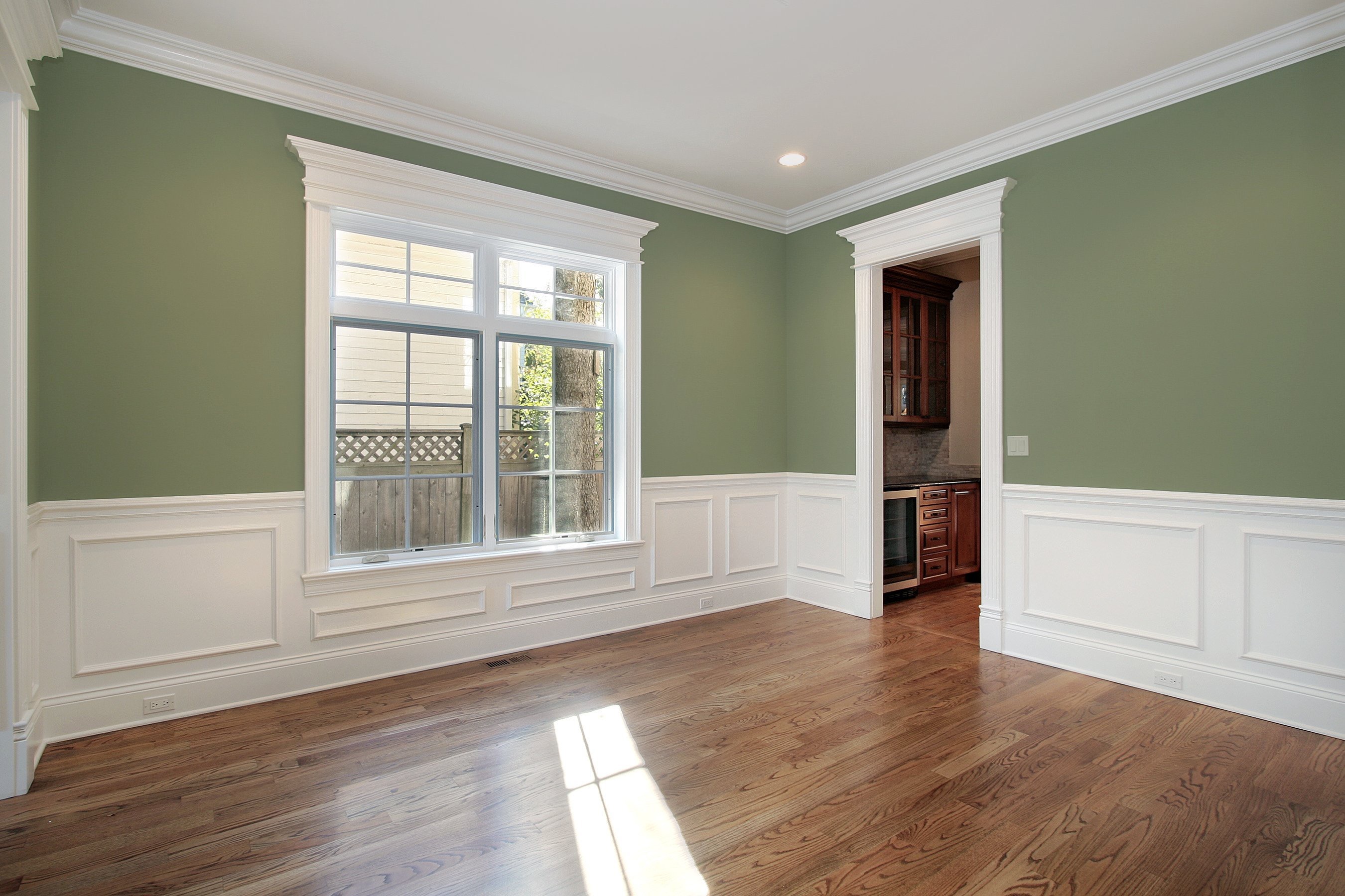 a room with green walls and white trim