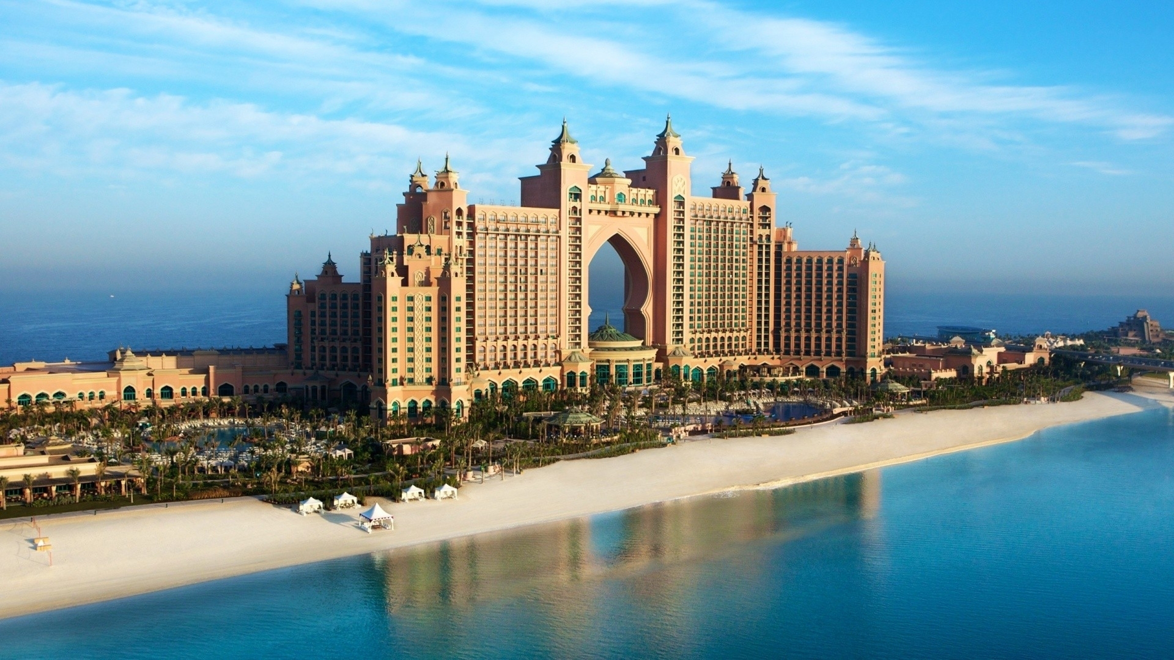 a large building with a large arch over a body of water with Atlantis, The Palm in the background