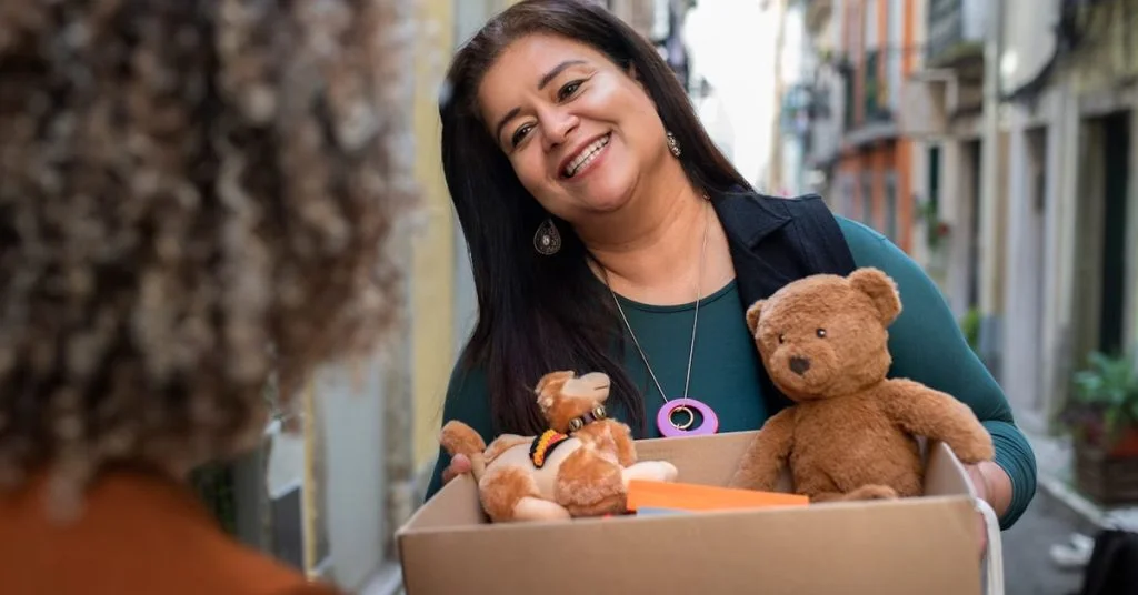 a woman holding a box of stuffed animals