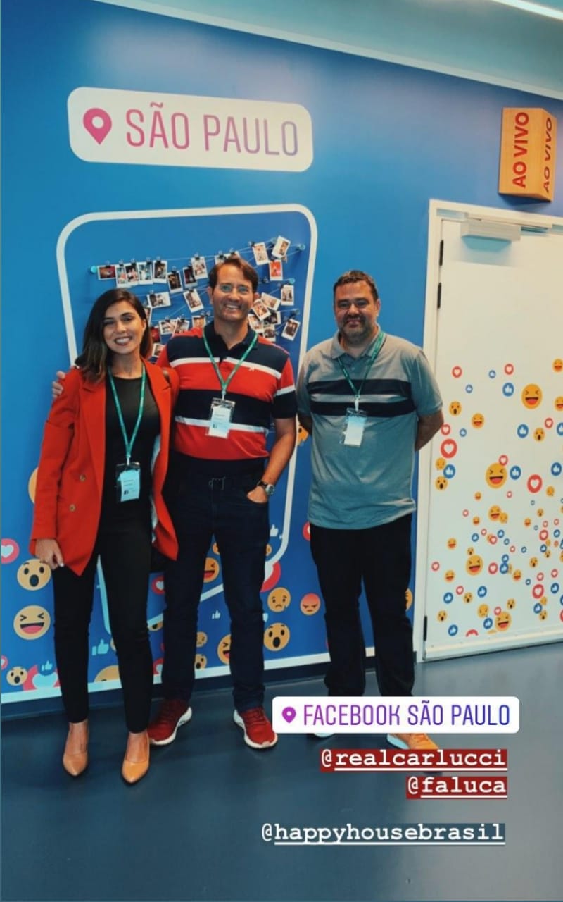 a group of people standing in front of a wall with emojis