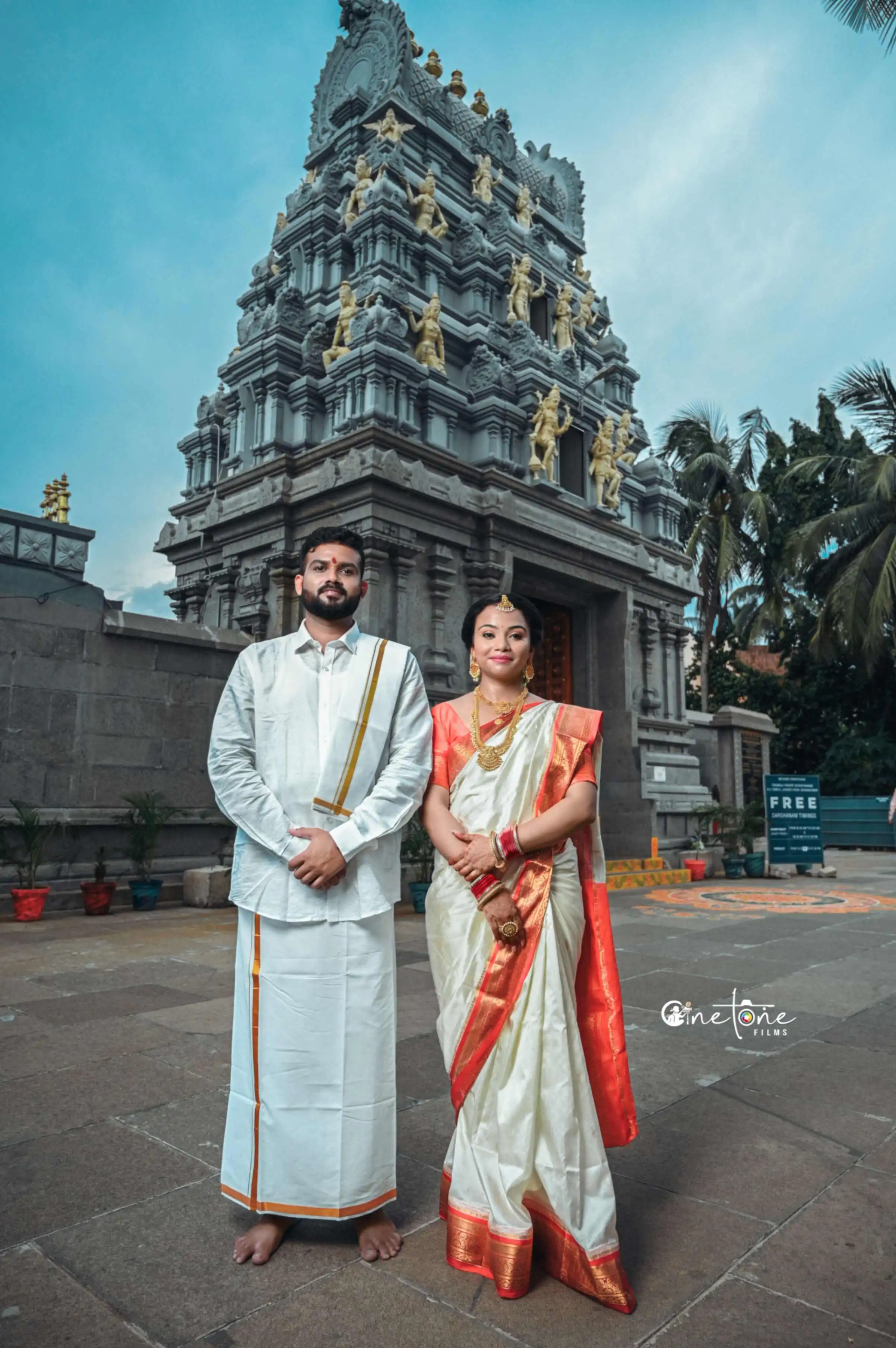 a man and woman in traditional indian attire standing in front of a building