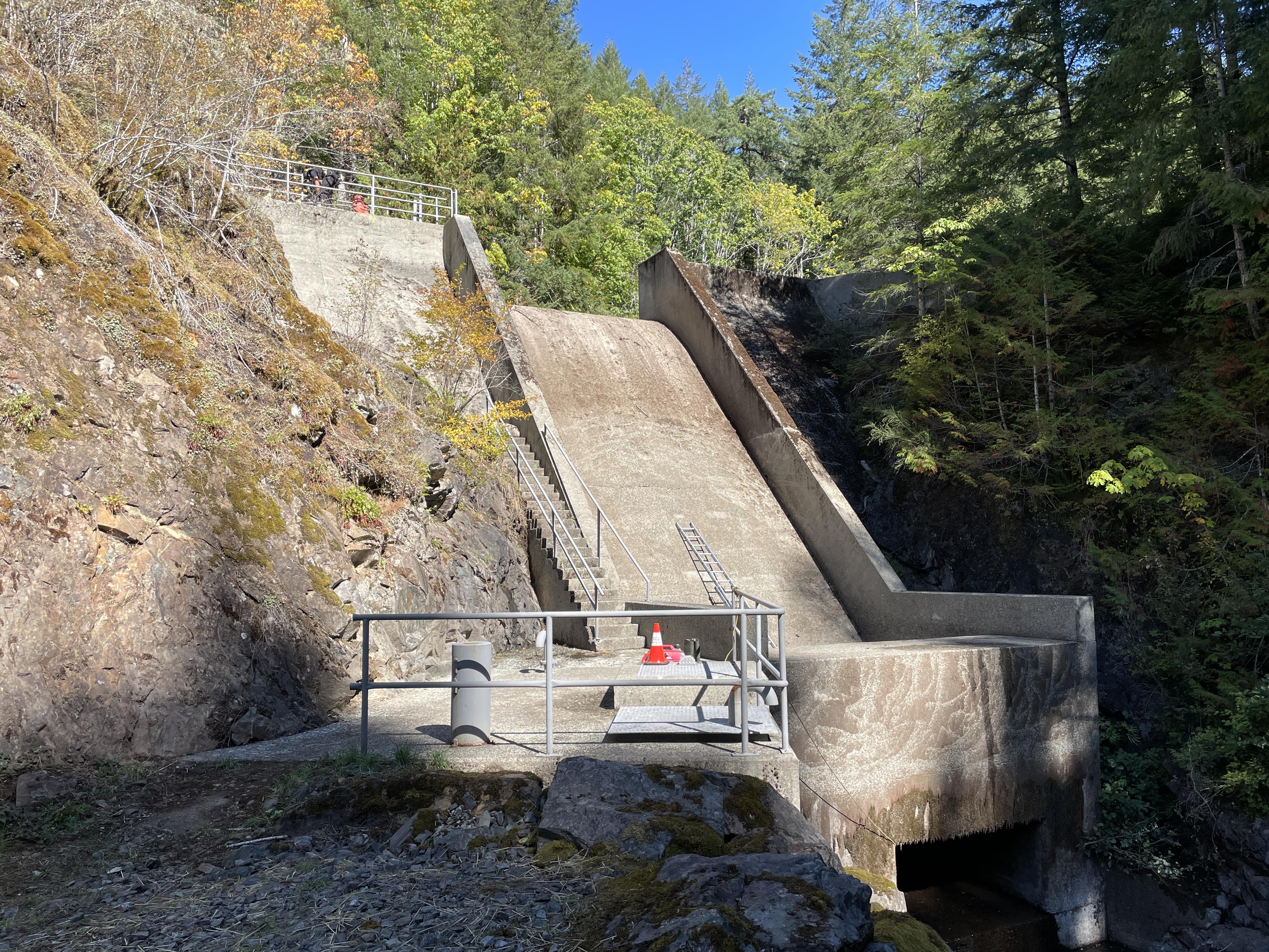 a concrete dam with a metal railing