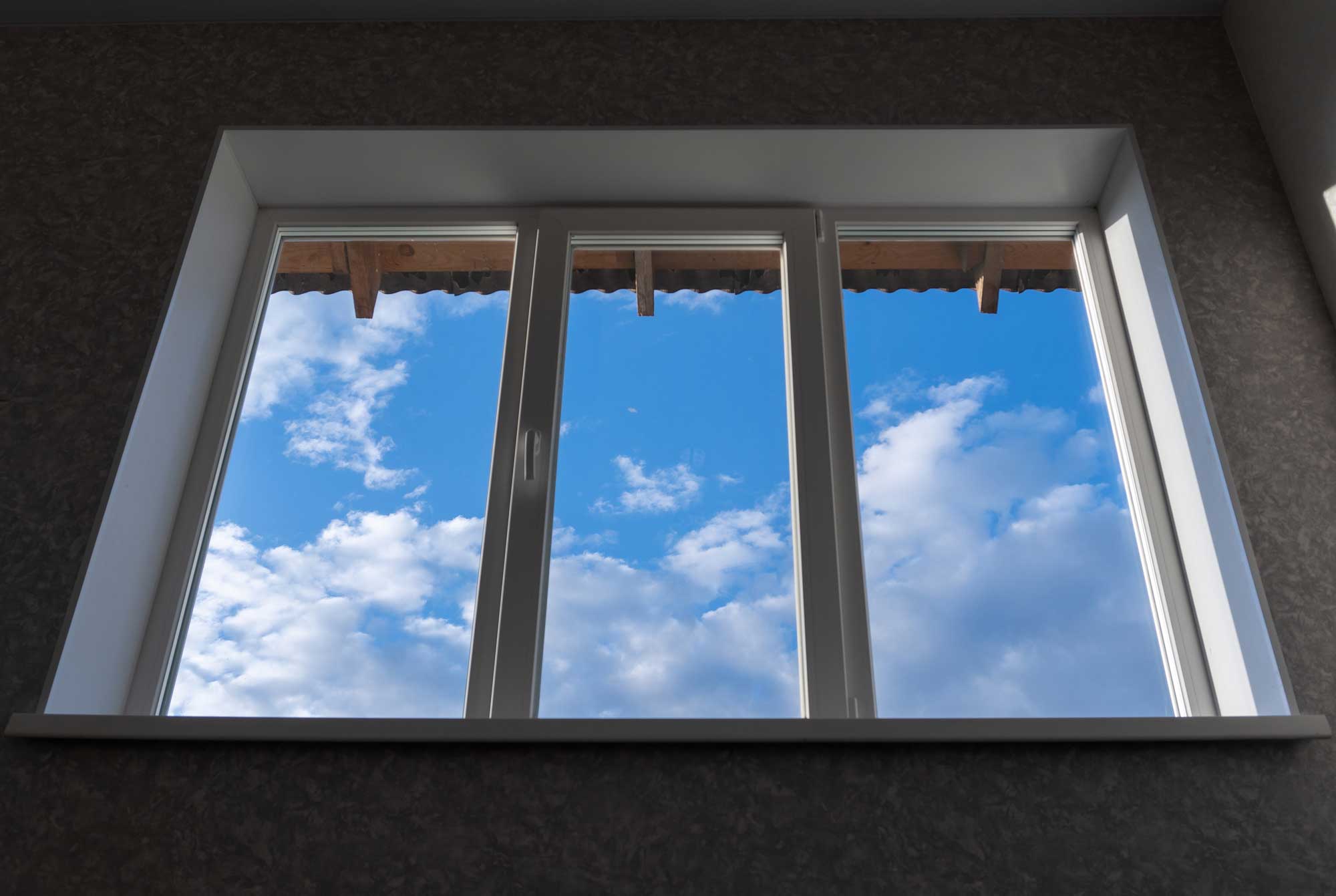 a window with a blue sky and clouds