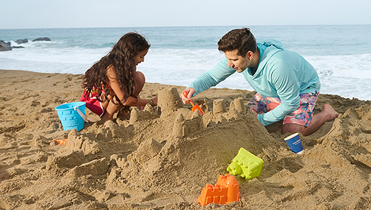 a man and woman building sandcastles on a beach