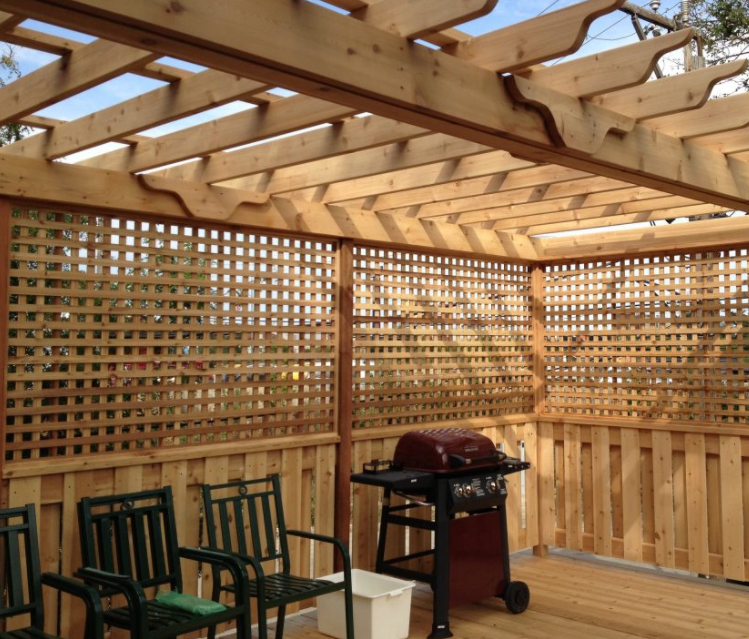 a wooden patio with a grill and chairs