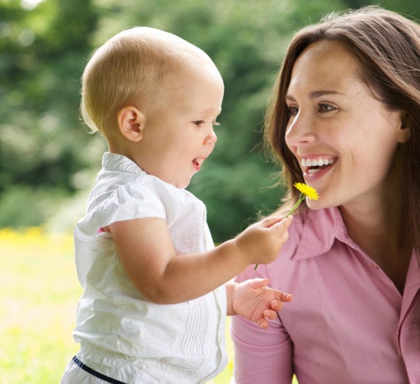 a woman and baby holding a flower