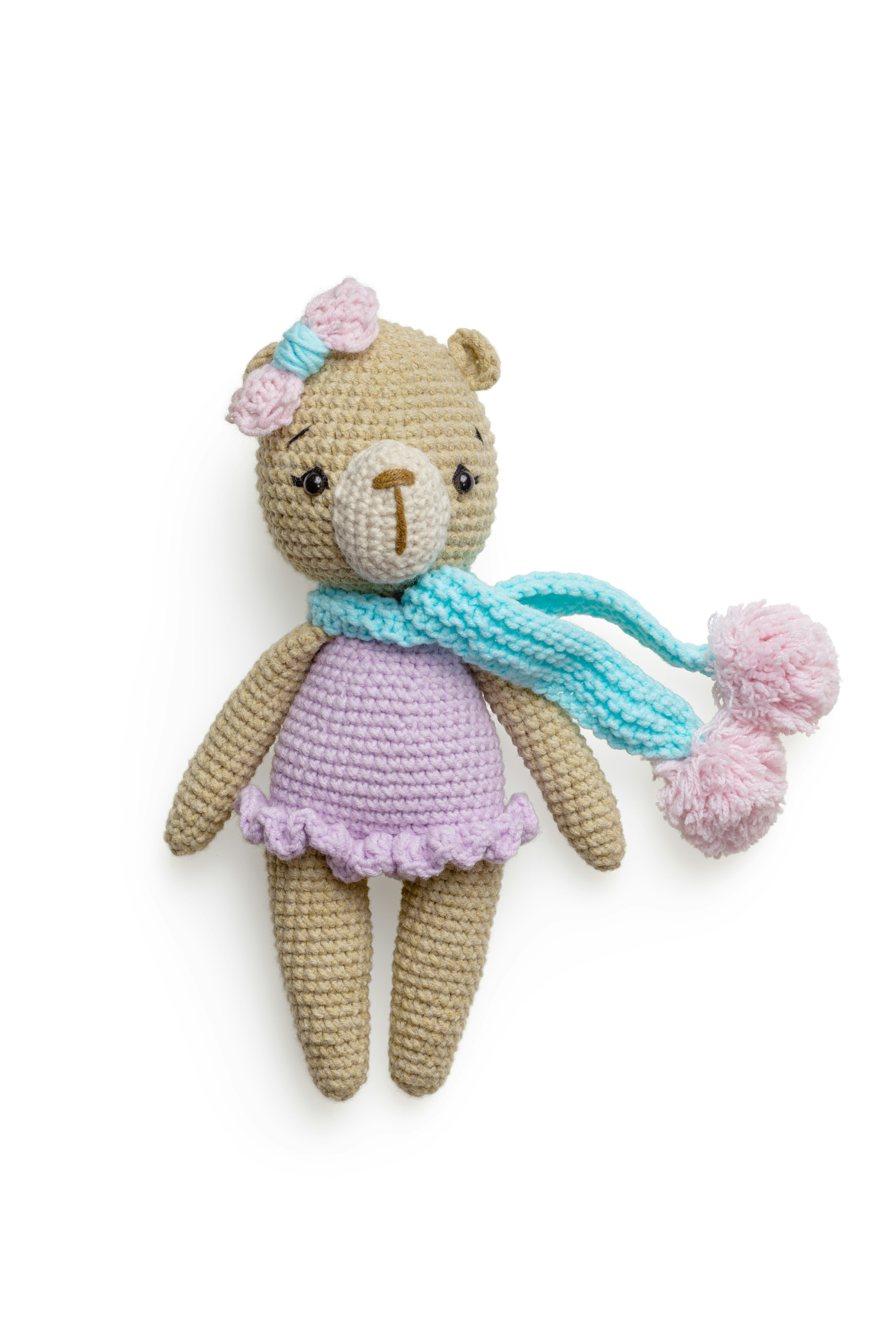 a knitted teddy bear wearing a scarf